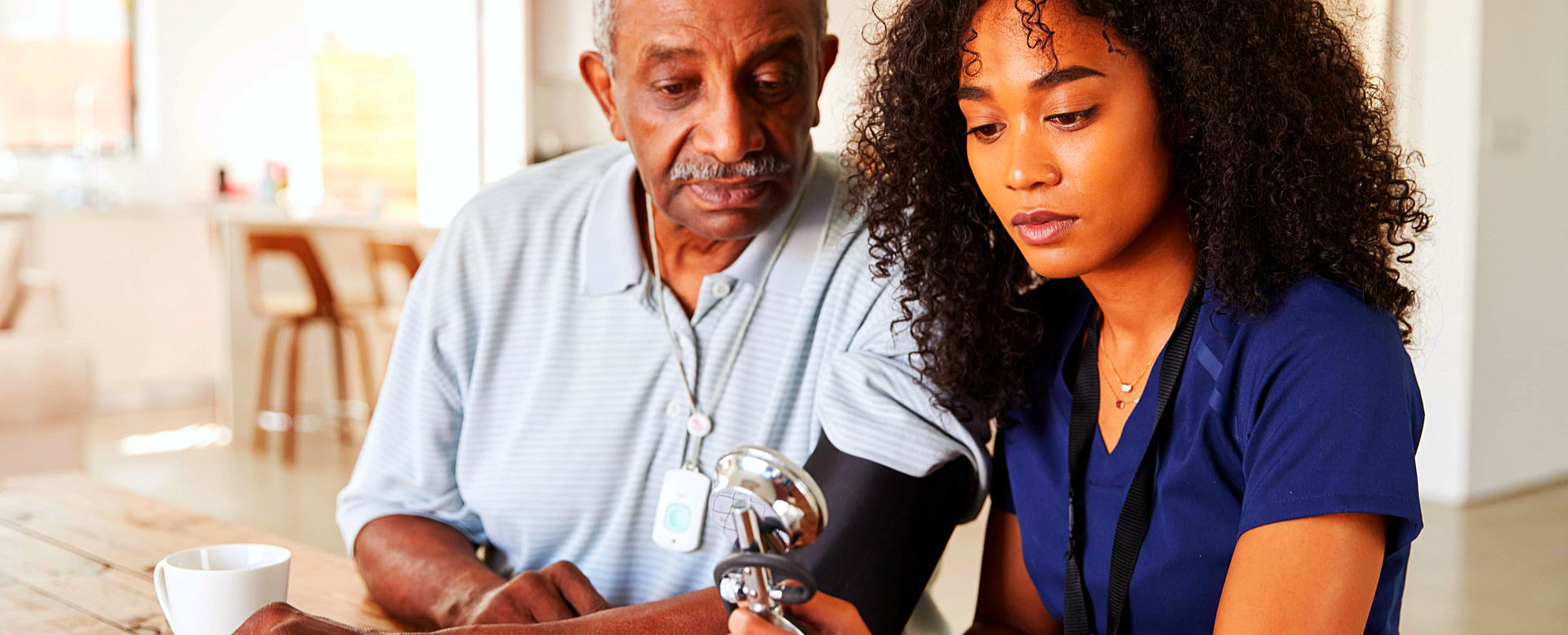 caregiver doing blood pressure monitoring to a senior man