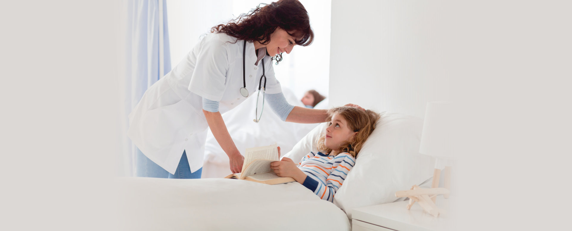 Caring young nurse looking after little sick girl