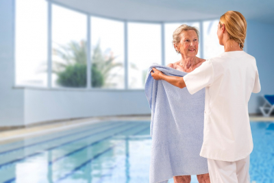 caregiver giving towel to a senior woman