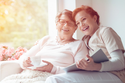 senior woman and a caregiver smiling