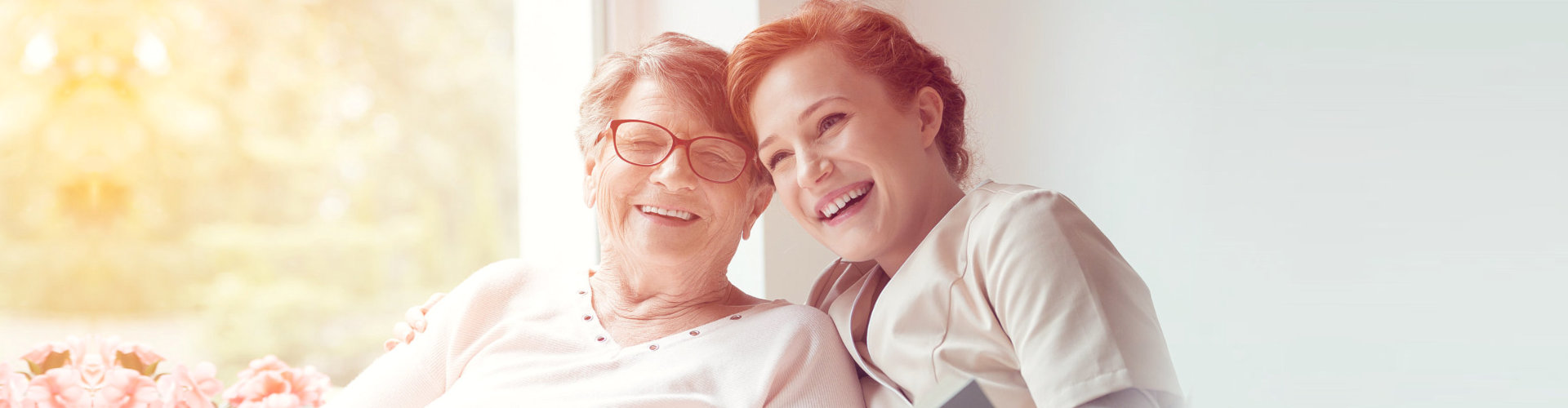 senior woman and a caregiver smiling